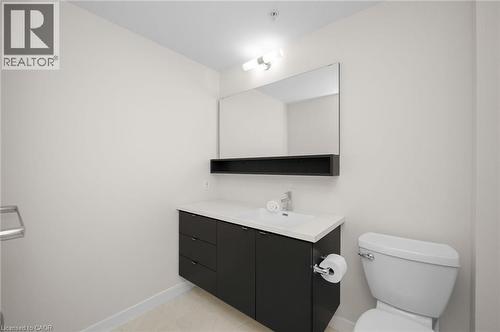 Bathroom with a dark wood-finish floating vanity, white countertop, and integrated rectangular sink - 10 Esplanade Lane Unit# 310, Grimsby, ON - Indoor Photo Showing Bathroom