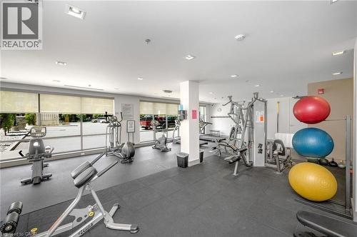 Spacious fitness center featuring expansive window walls, recessed lighting, durable rubber flooring, and multiple workout stations - 10 Esplanade Lane Unit# 310, Grimsby, ON - Indoor Photo Showing Gym Room