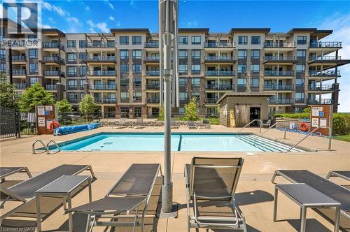 Outdoor swimming pool with integrated steps, surrounded by a concrete deck - 10 Esplanade Lane Unit# 310, Grimsby, ON - Outdoor With In Ground Pool