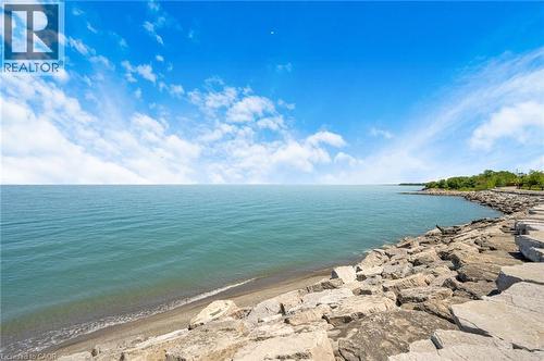 Expansive waterfront property featuring a stone breakwall, natural shoreline, and direct water access - 10 Esplanade Lane Unit# 310, Grimsby, ON - Outdoor With Body Of Water With View