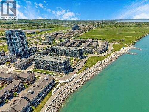 Waterfront property featuring diverse residential architecture, a paved shoreline path, and extensive surrounding green space - 10 Esplanade Lane Unit# 310, Grimsby, ON - Outdoor With Body Of Water With View