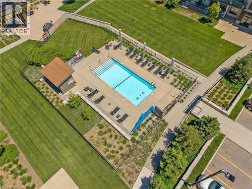Fenced rectangular swimming pool with integrated steps, surrounded by a concrete patio and sun loungers - 10 Esplanade Lane Unit# 310, Grimsby, ON - Outdoor With In Ground Pool With View
