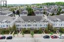 Contemporary townhome exterior featuring light gray siding, dark gray shingle roofing, and red entry doors - 619 Wild Ginger Avenue Unit# C15, Waterloo, ON  - Outdoor With Facade 
