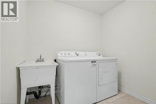 Dedicated laundry space with a utility sink, a top-loading washing machine, and a front-loading dryer - 619 Wild Ginger Avenue Unit# C15, Waterloo, ON - Indoor Photo Showing Laundry Room