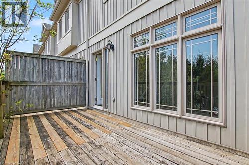 Private wooden deck featuring a privacy fence, exterior light fixture, and triple paned windows - 619 Wild Ginger Avenue Unit# C15, Waterloo, ON - Outdoor With Deck Patio Veranda With Exterior