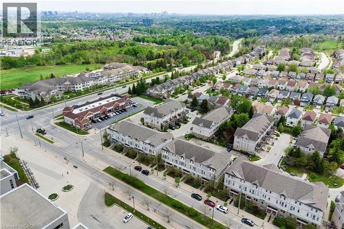 Aerial perspective showcasing a residential area featuring single-family homes, townhouses, and multi-unit buildings - 619 Wild Ginger Avenue Unit# C15, Waterloo, ON - Outdoor With View