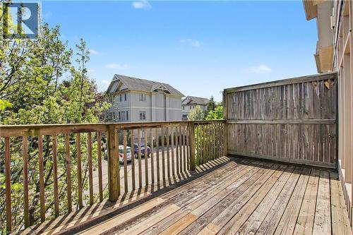 Outdoor wooden deck with a privacy fence, baluster railing, and natural light exposure - 619 Wild Ginger Avenue Unit# C15, Waterloo, ON - Outdoor With Exterior