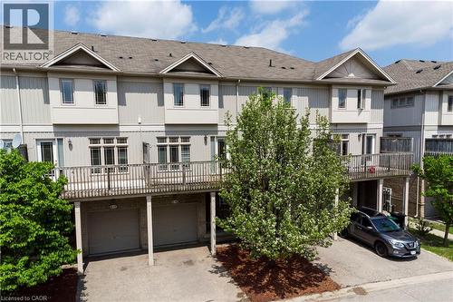 Multi-level townhome exterior with light-toned siding and a dark shingle roof - 619 Wild Ginger Avenue Unit# C15, Waterloo, ON - Outdoor