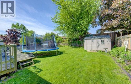Spacious rear yard featuring a wooden deck with steps, a detached storage shed, and mature perimeter trees - 96 Scott Road, Cambridge, ON - Outdoor With Backyard