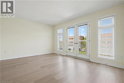 Expansive room featuring wood-finish flooring, light-colored walls, and white trim - 619 Wild Ginger Avenue Unit# C16, Waterloo, ON - Indoor Photo Showing Other Room