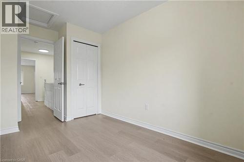 Light wood-finish flooring throughout, complemented by white baseboards and neutral wall tones - 619 Wild Ginger Avenue Unit# C16, Waterloo, ON - Indoor Photo Showing Other Room