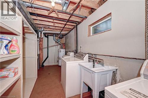 Utility space featuring exposed ceiling joists, concrete flooring, a utility sink, and built-in shelving - 92 Pinemeadow Crescent, Waterloo, ON - Indoor Photo Showing Laundry Room