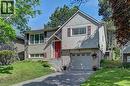 Split-level residence featuring a red entry door, attached garage, and a combination of brick and vertical siding finishes - 92 Pinemeadow Crescent, Waterloo, ON  - Outdoor With Facade 