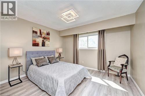 Spacious room featuring wood-finish flooring, a contemporary ceiling light fixture, and a window with drapes - 92 Pinemeadow Crescent, Waterloo, ON - Indoor Photo Showing Bedroom