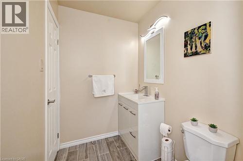 Bathroom featuring a white vanity with integrated sink, chrome faucet, wall-mounted mirror, and contemporary light fixture - 92 Pinemeadow Crescent, Waterloo, ON - Indoor Photo Showing Bathroom