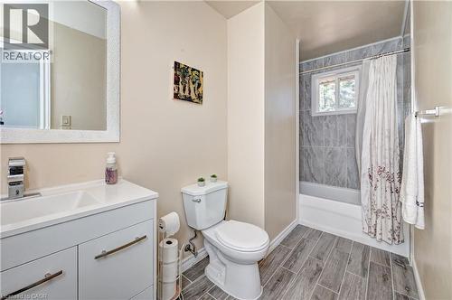Bathroom featuring a white vanity with integrated sink, chrome faucet, and a large framed mirror - 92 Pinemeadow Crescent, Waterloo, ON - Indoor Photo Showing Bathroom