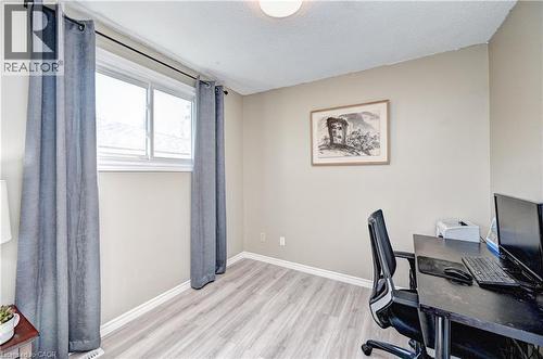 Room featuring wood-finish flooring, neutral wall paint, white trim, and a window with a white frame - 92 Pinemeadow Crescent, Waterloo, ON - Indoor Photo Showing Office
