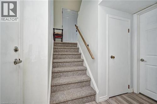 Carpeted staircase featuring a light wood-finish handrail - 92 Pinemeadow Crescent, Waterloo, ON - Indoor Photo Showing Other Room