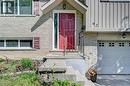 Stone facade exterior featuring a bright red entry door and a white paneled garage door - 92 Pinemeadow Crescent, Waterloo, ON  - Outdoor 