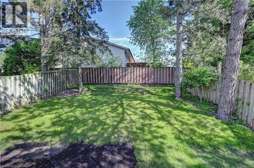Grassed outdoor space featuring mature trees and wood fencing - 92 Pinemeadow Crescent, Waterloo, ON - Outdoor