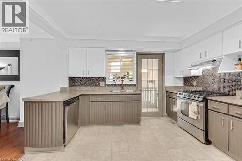 Spacious kitchen featuring light-colored tile flooring, white upper cabinetry, and contrasting lower cabinetry - 1 Galbraith Drive, Hamilton, ON - Indoor Photo Showing Kitchen