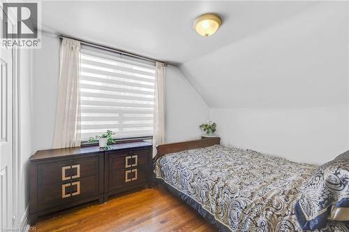 Room featuring a sloped ceiling, wood-finish flooring, and a window with blinds - 1 Galbraith Drive, Hamilton, ON - Indoor Photo Showing Bedroom