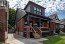 Brick and dark siding exterior with a covered front porch featuring dark columns and trim - 106 Grosvenor Avenue N, Hamilton, ON  - Outdoor 