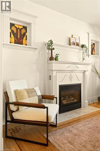 Fireplace with decorative mantle, integrated fireplace insert, and a light-toned hearth - 106 Grosvenor Avenue N, Hamilton, ON - Indoor Photo Showing Living Room With Fireplace