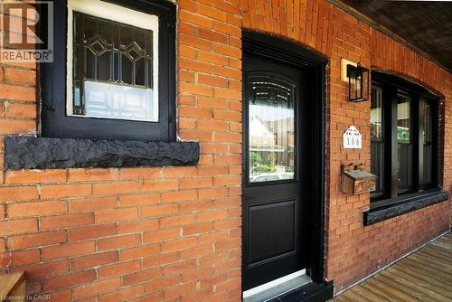 Brick exterior featuring black framed windows and an arched entryway door with decorative glass - 106 Grosvenor Avenue N, Hamilton, ON - Outdoor With Exterior