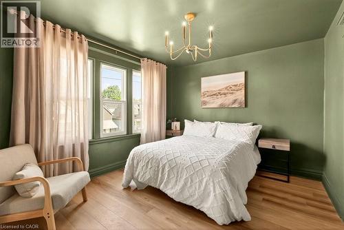 Bedroom featuring wood-finish flooring, a multi-pane window, and a ceiling-mounted light fixture - 106 Grosvenor Avenue N, Hamilton, ON - Indoor Photo Showing Bedroom