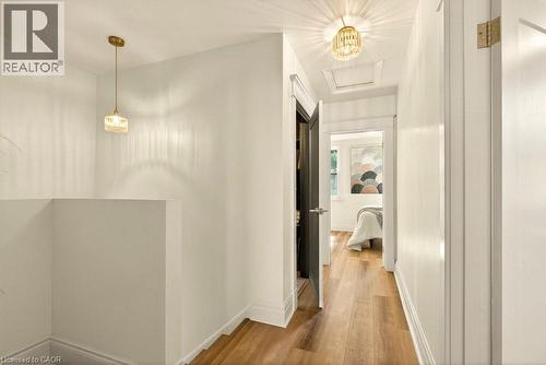 Hallway featuring wood-finish flooring, white walls, and bright overhead lighting - 106 Grosvenor Avenue N, Hamilton, ON - Indoor