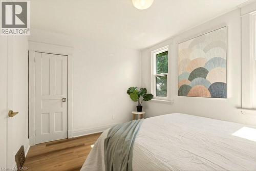 Bright interior space featuring wood-finish flooring and white painted walls - 106 Grosvenor Avenue N, Hamilton, ON - Indoor Photo Showing Bedroom