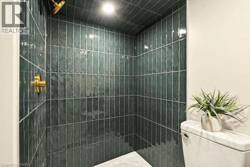 Shower with vertical emerald green subway tile, brass fixtures, and recessed lighting - 106 Grosvenor Avenue N, Hamilton, ON - Indoor Photo Showing Bathroom