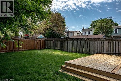 Expansive backyard featuring a multi-level wood deck, manicured lawn, and full perimeter wood fencing - 106 Grosvenor Avenue N, Hamilton, ON - Outdoor