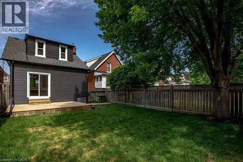 Expansive backyard featuring a manicured lawn, a large wood deck, and a privacy fence - 106 Grosvenor Avenue N, Hamilton, ON - Outdoor