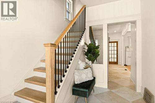 Hardwood staircase with black iron spindles and a natural wood newel post - 106 Grosvenor Avenue N, Hamilton, ON - Indoor Photo Showing Other Room