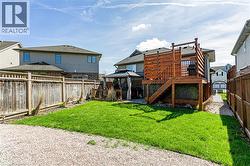 Expansive backyard featuring a well-maintained lawn, a spacious wooden deck with privacy screening, and a gazebo - 