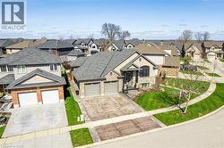 The property features a well-maintained lawn and a paved driveway leading to a two-car garage - 