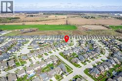 Aerial view of the neighborhood, featuring residential streets, green lawns, and surrounding fields - 