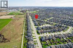 Aerial view showcasing the property within a residential neighborhood featuring paved streets and manicured lawns - 