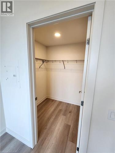 Expansive closet featuring wood-finish flooring, white baseboards, a built-in wire shelving system, and recessed ceiling lighting - 385 Winston Road Unit# 709, Grimsby, ON - Indoor