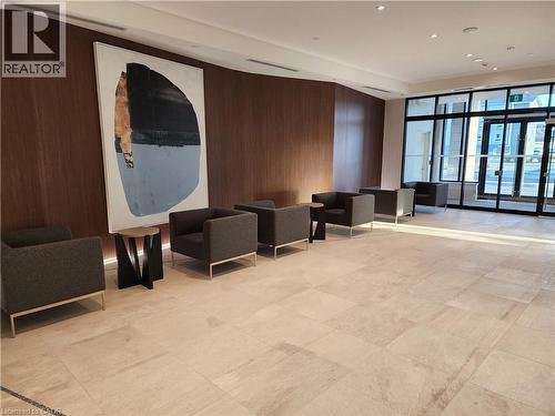 Lobby area with wood-panel accent wall, recessed lighting, and large format tile flooring - 385 Winston Road Unit# 709, Grimsby, ON - Indoor Photo Showing Other Room