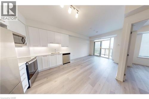 Open-concept living space with light wood-finish flooring - 385 Winston Road Unit# 709, Grimsby, ON - Indoor Photo Showing Kitchen