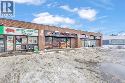 Commercial storefronts featuring brick exteriors, multiple display windows, and prominent signage - 402 King Street N, Waterloo, ON 