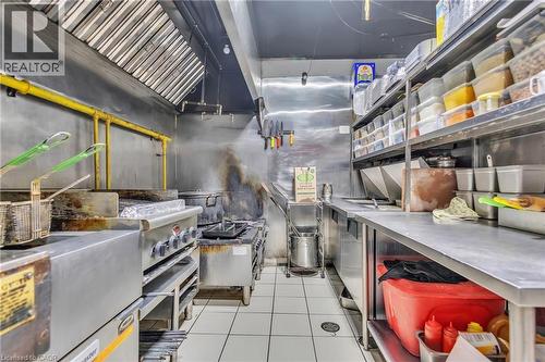Commercial-grade kitchen featuring stainless steel surfaces, integrated stovetop, and hood ventilation system - 402 King Street N, Waterloo, ON 
