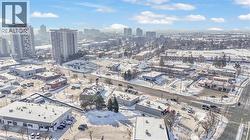 Urban landscape featuring multiple commercial buildings, paved roads, and distant high-rise structures - 