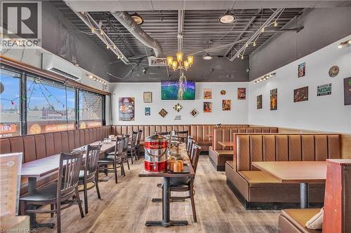 Interior dining space featuring wood-finish flooring and a mix of booth and table seating - 402 King Street N, Waterloo, ON 