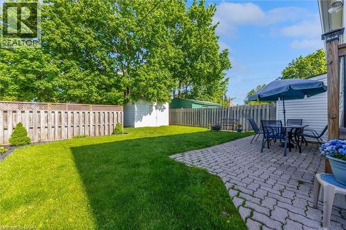 Expansive backyard featuring a green lawn, wood privacy fencing, and a paver patio - 121 Edgemont Street N, Hamilton, ON - Outdoor