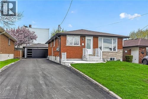 Brick and stone exterior with a prominent front entrance featuring white railings and steps - 74 Victor Boulevard, Hamilton, ON - Outdoor