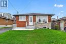Brick facade home featuring a stone veneer accent, white trim windows, and a front entry door with a storm door - 74 Victor Boulevard, Hamilton, ON  - Outdoor 